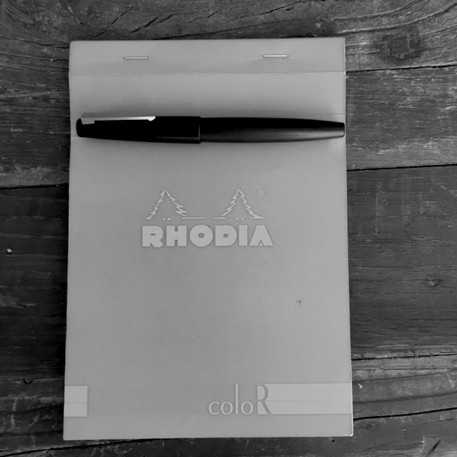 A blue Rhodia notebook and pen